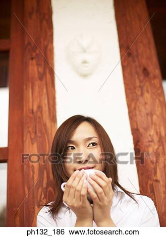 Young woman holding a cup of tea View Large Photo Image Stock Photograph - Young woman holding a cup of tea. Fotosearch