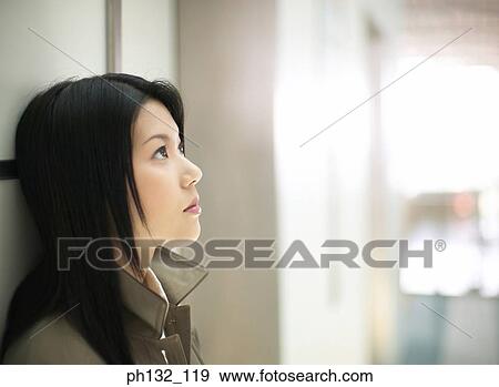 Stock Photo - Young woman looking up. Fotosearch