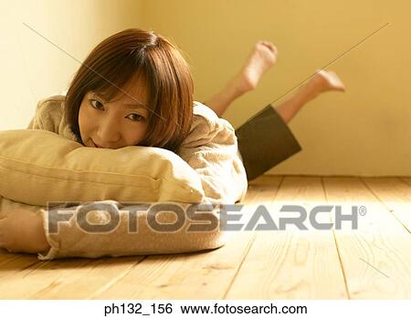 Young woman lying on floor View Large Photo Image Stock Photograph - Young woman lying on floor. Fotosearch