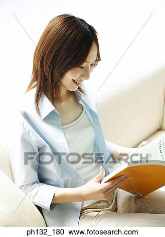 Stock Image - Young woman reading a book. Fotosearch