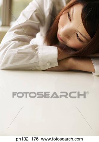Young woman resting her head on her arms View Large Photo Image Stock Photograph - Young woman resting her head on her arms. Fotosearch