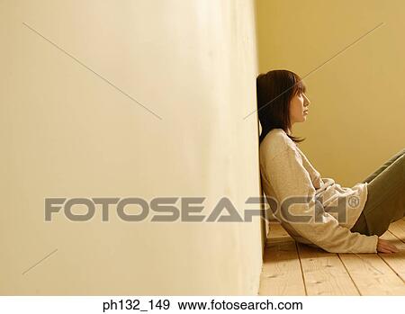 Stock Photo - Young woman sitting on floor. Fotosearch