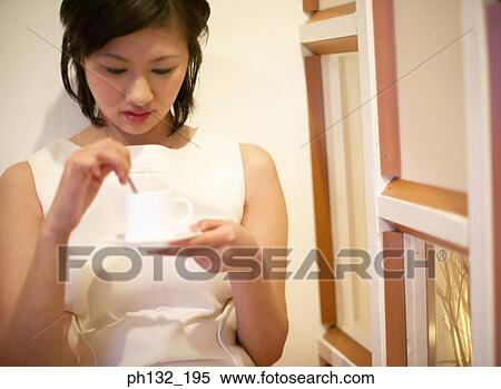Young woman stirring tea View Large Photo Image Stock Photography - Young woman stirring tea. Fotosearch