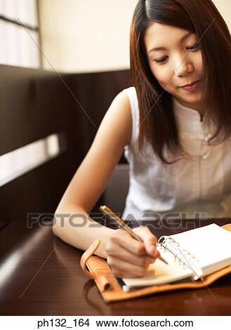 Picture - Young woman taking notes. Fotosearch