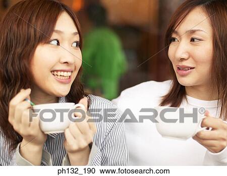 Young women enjoying a drink View Large Photo Image Stock Image - Young women enjoying a drink. Fotosearch