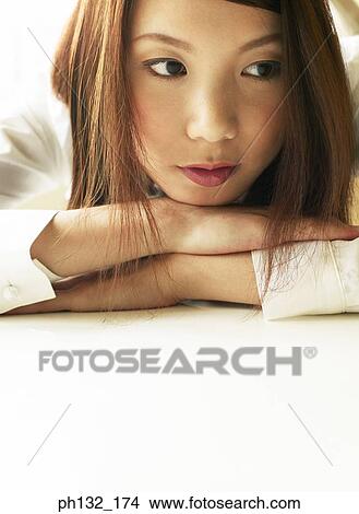 Picture - Young women resting her face on her arms. Fotosearch