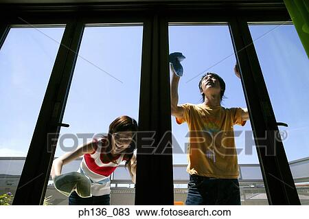 Stock Image - Young couple cleaning windows. Fotosearch