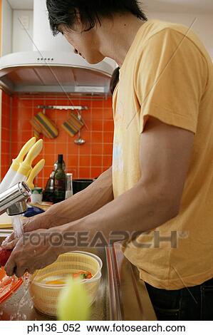 Stock Image - Young man cooking in the kitchen. Fotosearch