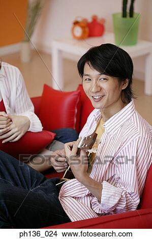 Young man playing a guitar looking at camera View Large Photo Image Picture - Young man playing a guitar looking at camera. Fotosearch