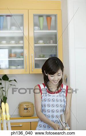 Young woman working in the kitchen View Large Photo Image Stock Image - Young woman working in the kitchen. Fotosearch