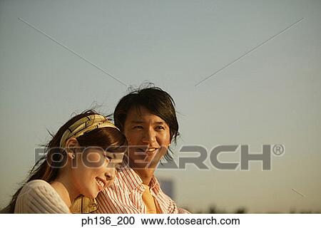 A young couple standing together View Large Photo Image Stock Image - A young couple standing together. Fotosearch