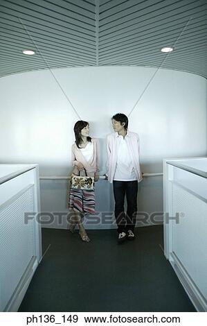 Stock Photo - Young couple Leaning against a railing. Fotosearch