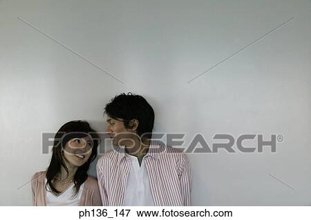 Young couple Leaning against a wall View Large Photo Image Stock Photo - Young couple Leaning against a wall. Fotosearch