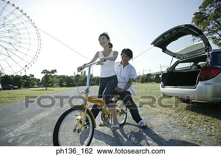 Young couple Riding a bicycle View Large Photo Image Stock Image - Young couple Riding a bicycle. Fotosearch