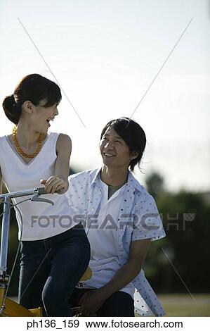 Young couple Riding a bicycle View Large Photo Image Stock Photo - Young couple Riding a bicycle. Fotosearch