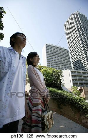 Young couple standing together outdoors View Large Photo Image Stock Photo - Young couple standing together outdoors. Fotosearch