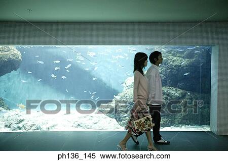 Stock Photography - Young couple walking by an aquarium. Fotosearch