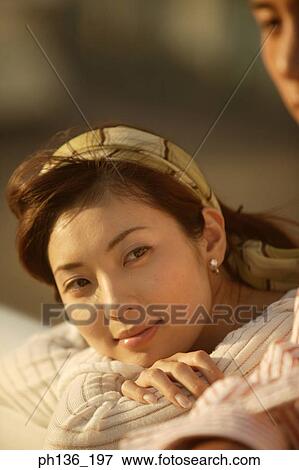 Stock Photo - Young woman Resting on a railing. Fotosearch
