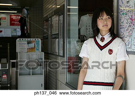 Stock Photograph - Teenage girl Leaning against a wall. Fotosearch