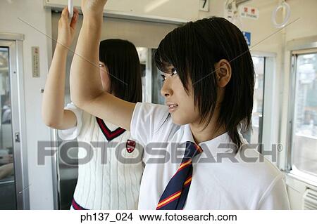 Teenage girls standing in a train View Large Photo Image Picture - Teenage girls standing in a train. Fotosearch