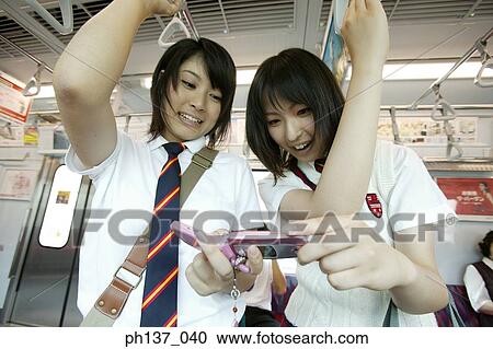 Teenage girls standing in a train View Large Photo Image Stock Image - Teenage girls standing in a train. Fotosearch