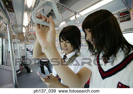 Teenage girls standing in a train View Large Photo Image Stock Photo - Teenage girls standing in a train. Fotosearch