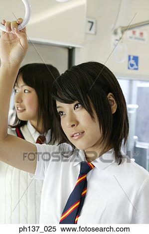 Stock Photography - Teenage girls standing in a train. Fotosearch