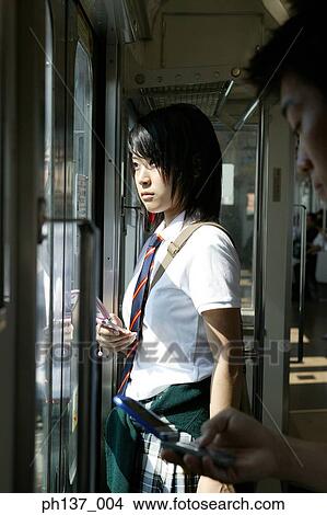 Picture - Teenagers in a train operating mobile phones. Fotosearch