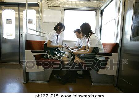 Stock Photography - Teenagers sitting in a train talking. Fotosearch