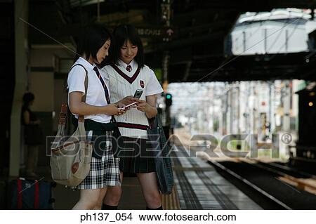 Two teenage girls standing at a train station View Large Photo Image Picture - Two teenage girls standing at a train station. Fotosearch