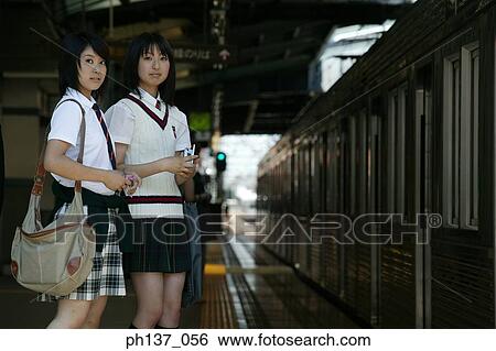 Two teenage girls standing at a train station View Large Photo Image Stock Photograph - Two teenage girls standing at a train station. Fotosearch