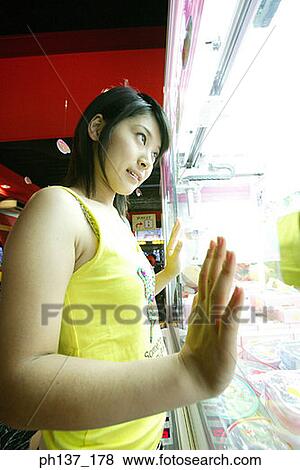 Teenage girl looking through a glass showcase View Large Photo Image Stock Photo - Teenage girl looking through a glass showcase. Fotosearch