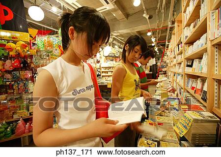 Teenagers looking at books in a store View Large Photo Image Stock Image - Teenagers looking at books in a store. Fotosearch