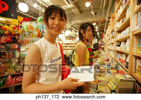 Teenagers looking at books in a store View Large Photo Image Stock Image - Teenagers looking at books in a store. Fotosearch