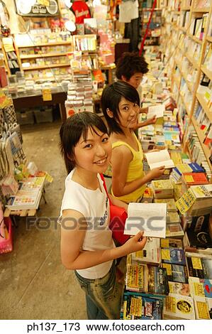 Stock Image - Teenagers looking at books in a store. Fotosearch