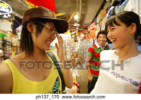 Teenagers looking at hats in a store View Large Photo Image Stock Image - Teenagers looking at hats in a store. Fotosearch