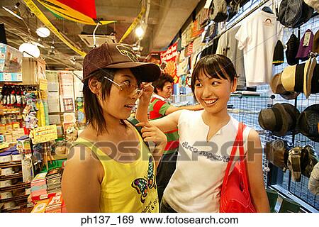 Teenagers looking at hats in a store View Large Photo Image Stock Photo - Teenagers looking at hats in a store. Fotosearch