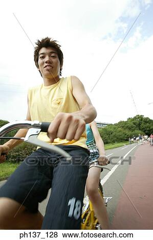 Teenagers riding a tandem bicycle View Large Photo Image Stock Photo - Teenagers riding a tandem bicycle. Fotosearch