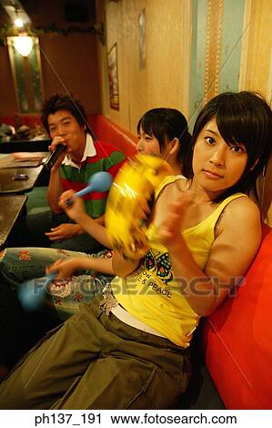 Teenagers singing at a karaoke bar View Large Photo Image Stock Image - Teenagers singing at a karaoke bar. Fotosearch