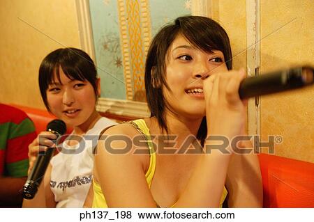 Stock Photo - Teenagers singing at a karaoke bar. Fotosearch