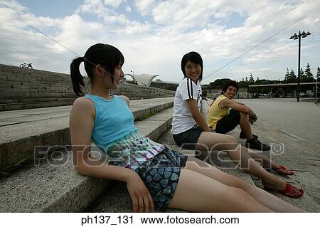 Stock Image - Teenagers sitting on steps. Fotosearch