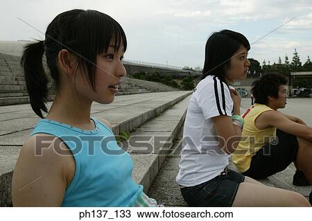Stock Image - Teenagers sitting on steps. Fotosearch