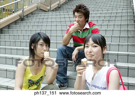 Teenagers sitting together eating ice cream View Large Photo Image Stock Image - Teenagers sitting together eating ice cream. Fotosearch