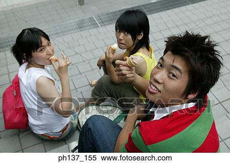 Teenagers sitting together eating ice cream View Large Photo Image Stock Photography - Teenagers sitting together eating ice cream. Fotosearch
