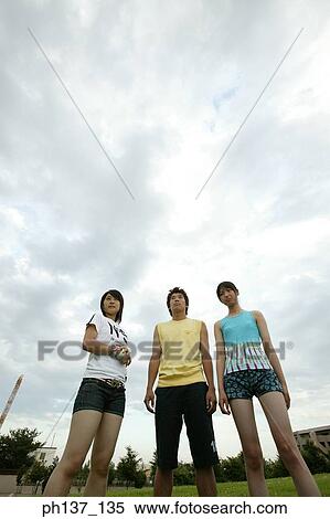 Teenagers standing on a lawn View Large Photo Image Stock Photography - Teenagers standing on a lawn. Fotosearch