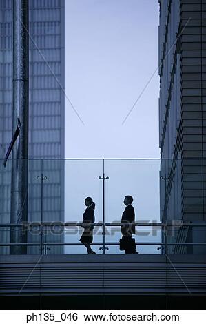 Low angle view of two executives walking on a bridge View Large Photo Image Stock Photograph - Low angle view of two executives walking on a bridge. Fotosearch