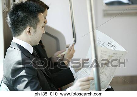 Stock Image - Side profile of young business executives traveling to work. Fotosearch