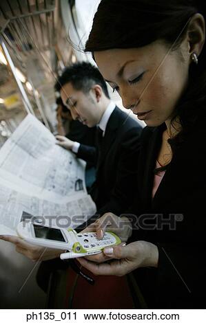 Stock Image - Side profile of young business executives traveling to work. Fotosearch