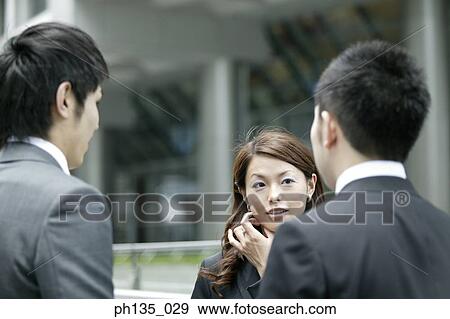 Stock Photo - Three co-workers talking outdoors. Fotosearch