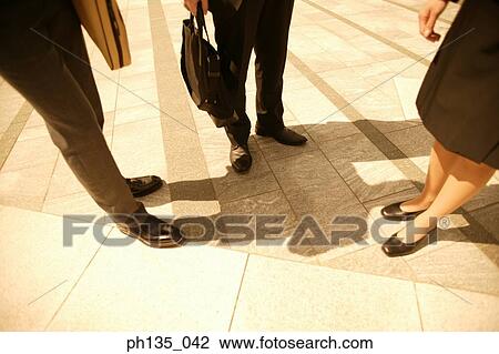 View of the legs of three co-workers standing outdoors View Large Photo Image Stock Image - View of the legs of three co-workers standing outdoors. Fotosearch